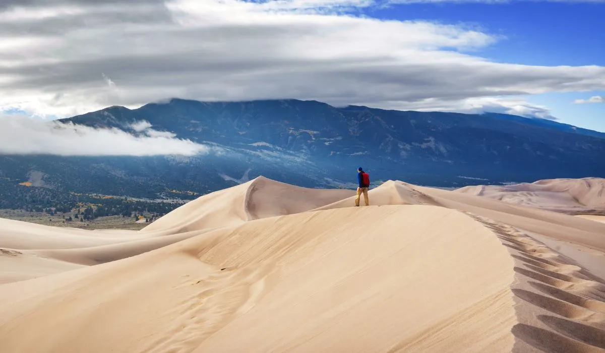 hiker walking across the Great Sand Dunes